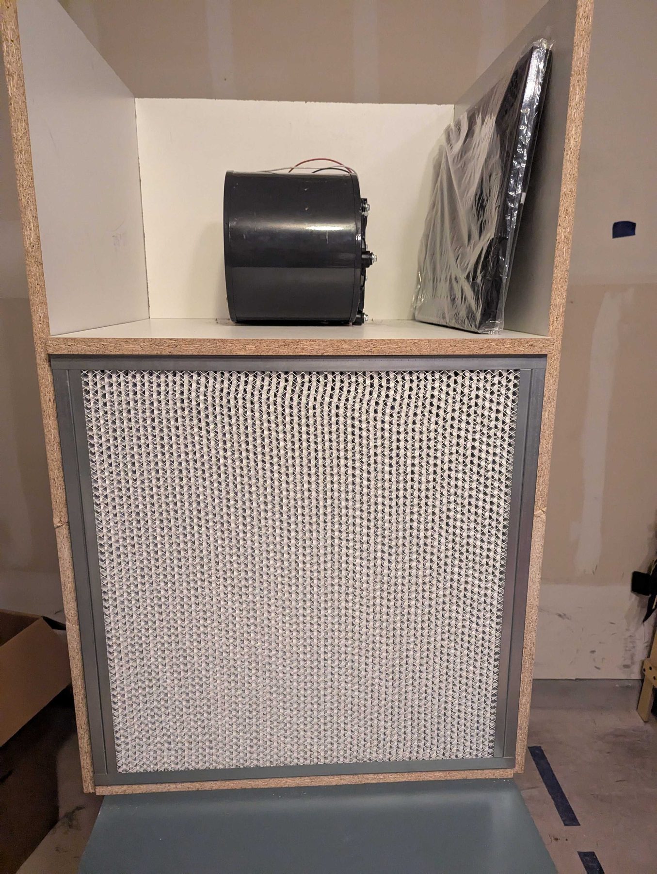 A laminar flow hood part built, its HEPA filter panel seated into a white timber frame.